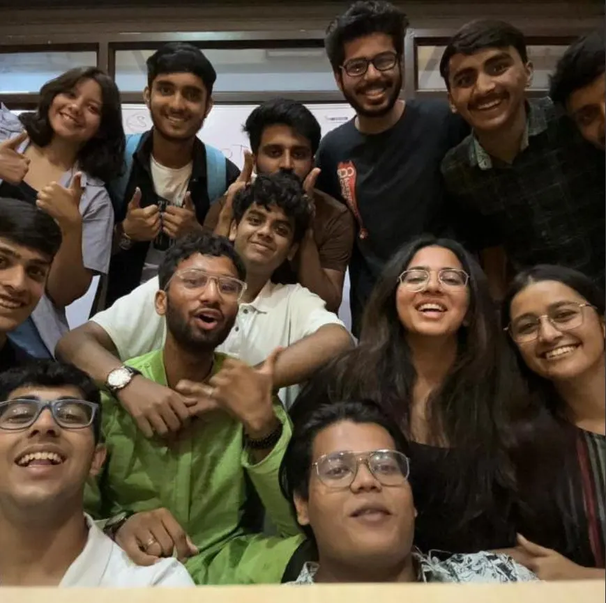 A dozen members packed into a close group photo at the end of a meeting.